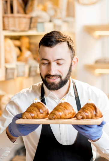 Young baker creating artisanal bread in a small business shop.