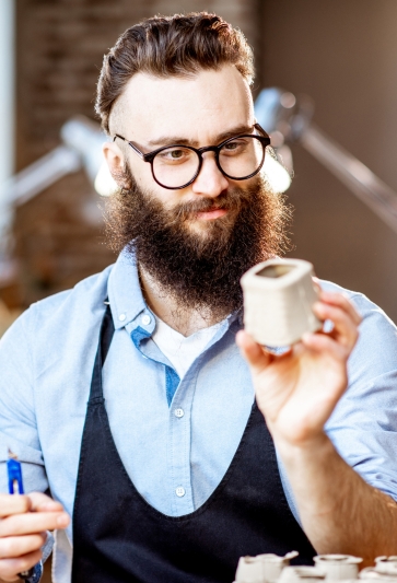 Young potter creating unique pottery in a small business shop, showcasing global business solutions through craftsmanship.