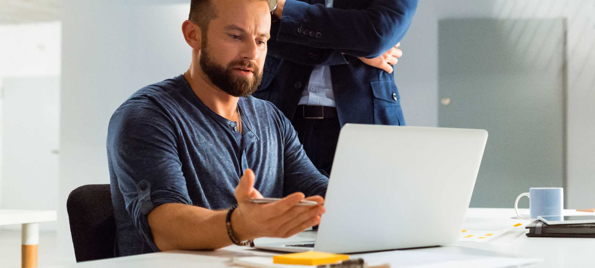 Entrepreneur discussing business trends with partner over laptop.